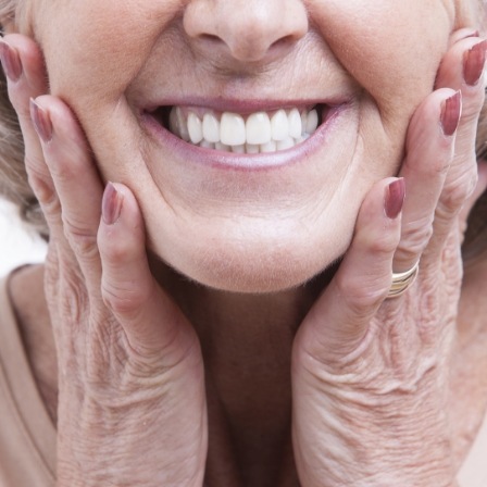 Smiling senior woman touching her face