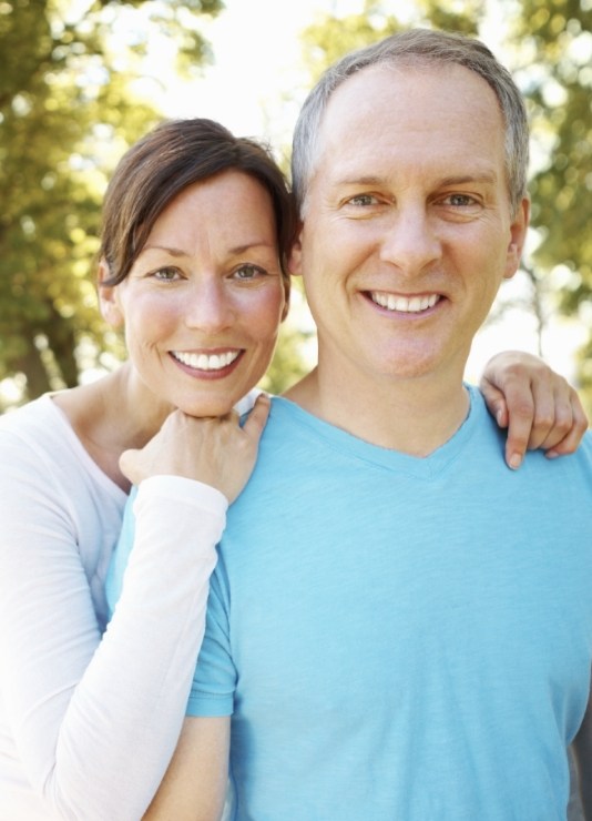 Man and woman smiling outdoors after teeth whitening in Oklahoma City