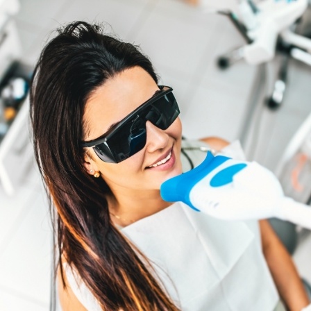 Woman getting professional teeth whitening in dental office